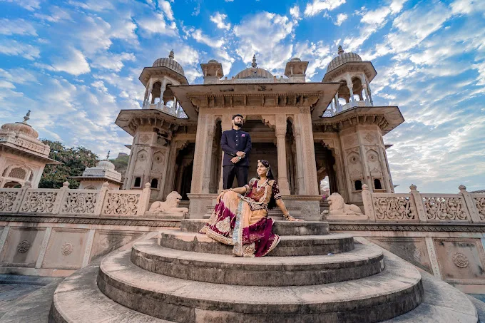 a man and woman posing in front of a building