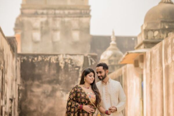 Couple posing in traditional Rajasthani attire during a pre-wedding photoshoot at a historic palace in Rajasthan, capturing the essence of romance and heritage.