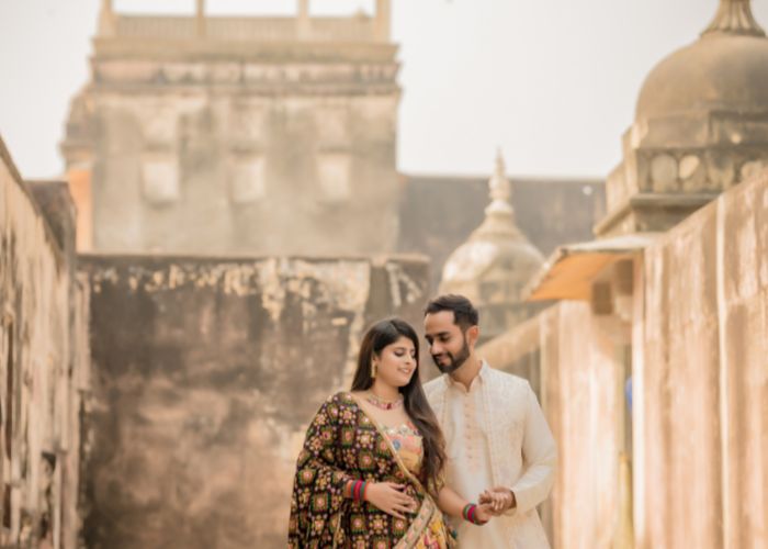 Couple posing in traditional Rajasthani attire during a pre-wedding photoshoot at a historic palace in Rajasthan, capturing the essence of romance and heritage.