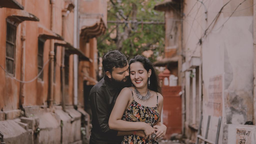 A couple shares a romantic moment in a charming narrow alley during their pre-wedding shoot in Jaipur.