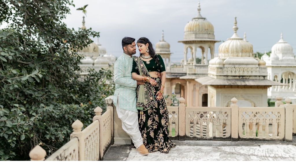 A couple in traditional attire poses for a pre-wedding shoot against the beautiful backdrop of Jaipur's palatial architecture.