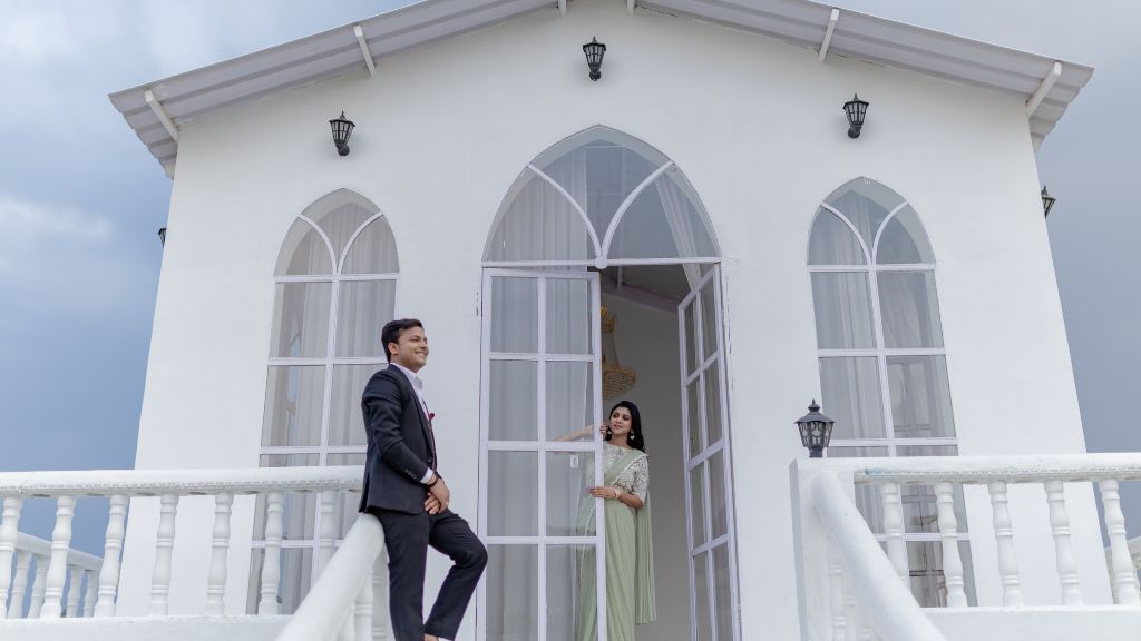 A couple poses for a stylish pre-wedding shoot in Jaipur in front of a beautiful white architectural structure.