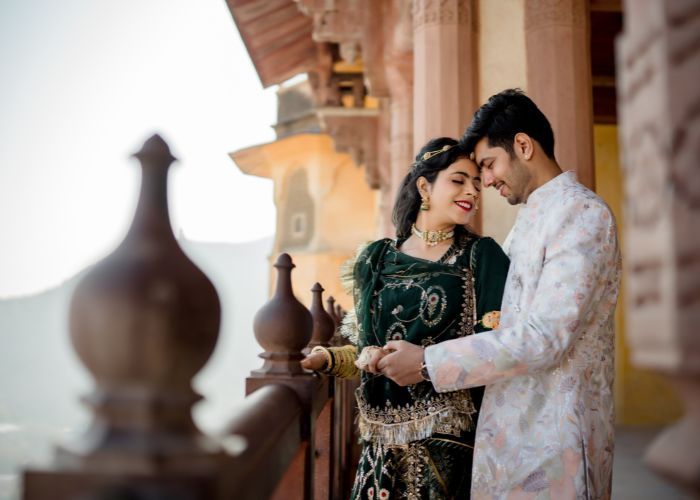 Couple posing in traditional Rajasthani attire during a pre-wedding photoshoot at a historic palace in Rajasthan, capturing the essence of romance and heritage."