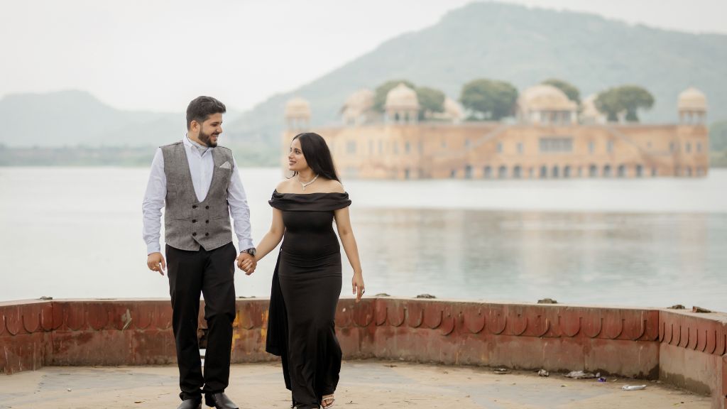 Pre-Wedding Shoot Locations in JaipurA couple walking hand-in-hand during a pre-wedding shoot in Jaipur, with the iconic Jal Mahal in the background.