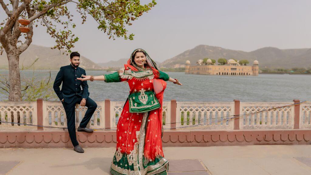 A couple embracing the elegance of a Pre-Wedding Shoot in Jaipur, standing against the scenic backdrop of Jal Mahal, with tranquil waters and majestic architecture adding to the romance.