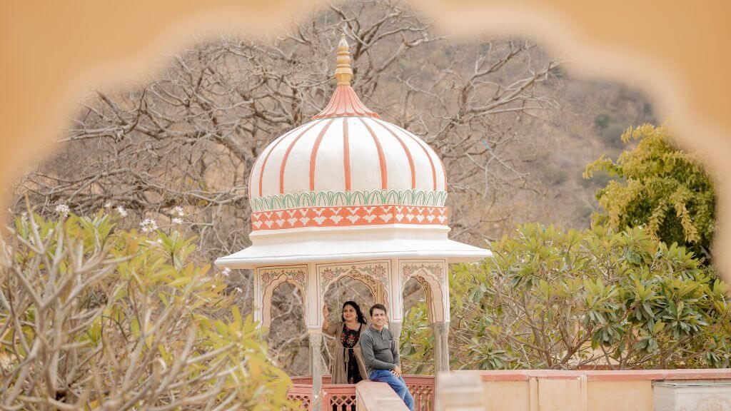 Couple posing under a dome at Sisodia Rani Garden in Jaipur, showcasing simple and charming pre wedding shoot outfit ideas.
