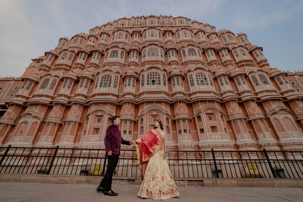 A couple posing gracefully in a pre-wedding shoot in Jaipur, with stunning historical architecture as the backdrop.