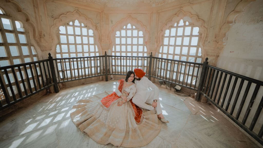 Couple posing in vintage style at Neemrana Fort during a pre wedding shoot in Jaipur with antique interiors