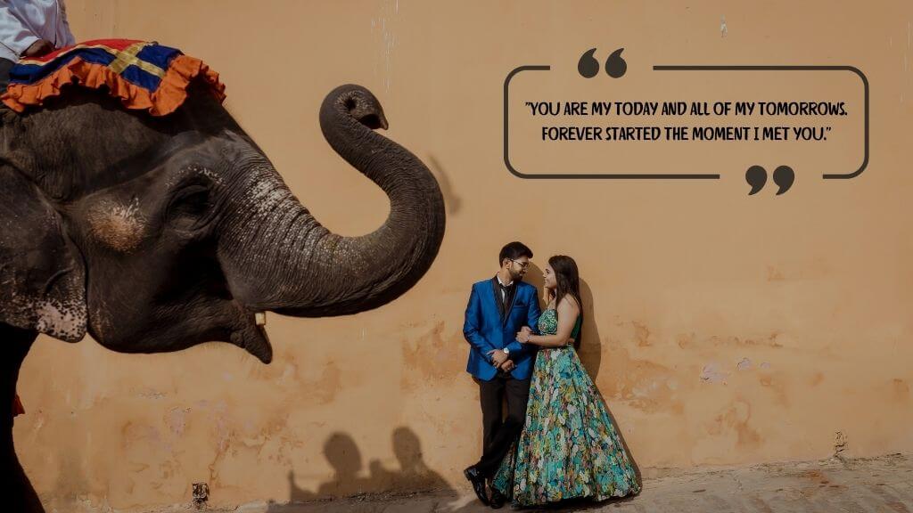 A romantic Indian couple posing beside a decorated elephant against a rustic orange wall, with a quote: “You are my today and all of my tomorrows. Forever started the moment I met you.” — perfect for wedding-themed content.