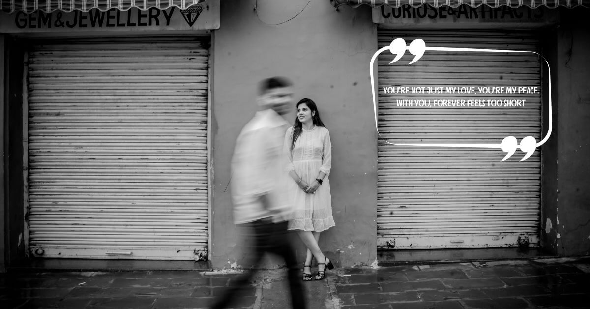 A black and white image of a woman standing by a closed shop shutter while her partner walks past in motion blur, overlaid with the quote: “You’re not just my love, you’re my peace. With you, forever feels too short.” — perfect for couple quotes for wedding content.