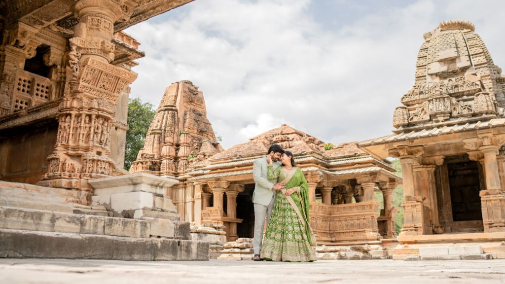 Couple posing for a romantic pre-wedding shoot in Udaipur at an ancient temple with intricate architecture